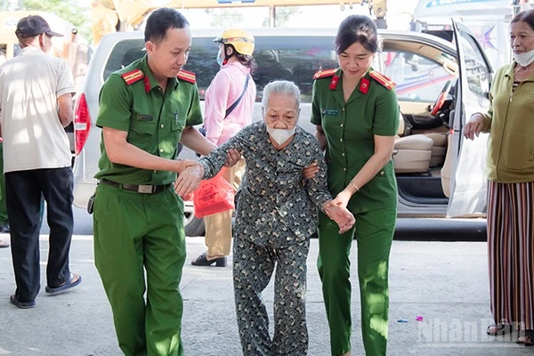 Cán bộ, chiến sĩ Công an xã Phú Ninh hỗ trợ người cao tuổi đi làm giấy tờ cá nhân.