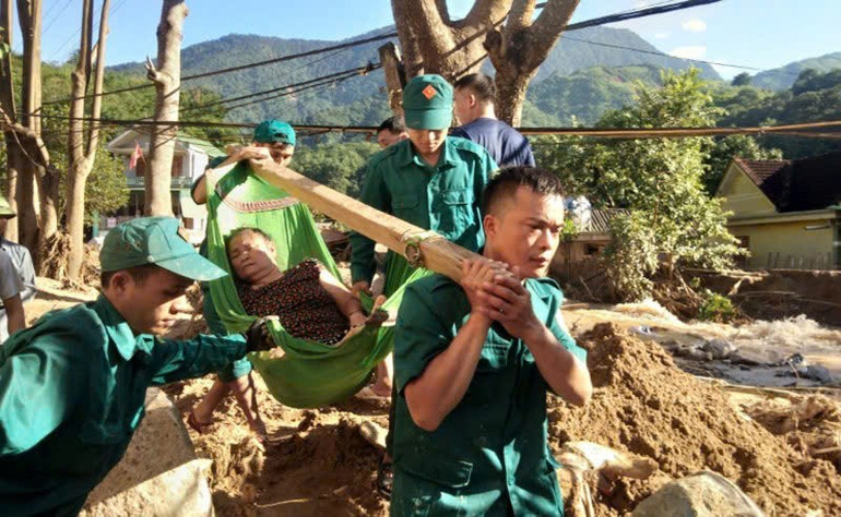 Vi Văn Hiếu (đi trước) tham gia đưa bệnh nhân tại vùng lũ xã Tà Cạ đi cấp cứu (ảnh chụp tháng 10/2022). z6833617011432-aa78b3daa3ea57f5f708294975ee129c.jpg