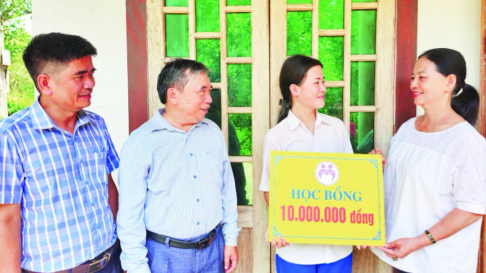 Cô Thái Thị Lan trao học bổng tặng em Tạ Trần Thị Nhi trước sự chứng kiến của lãnh đạo Phòng Giáo dục và Đào tạo huyện Gio Linh và Hiệu trưởng nhà trường.