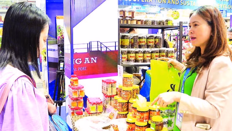Doanh nghiệp giới thiệu mắm chua, mắm ruốc, muối tôm Chân Ý (Tây Ninh) tại một hội chợ. (Ảnh LAN NGỌC)