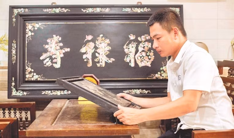 Nghệ nhân trẻ Phan Tấn Đạt bên một sản phẩm khảm ốc.
