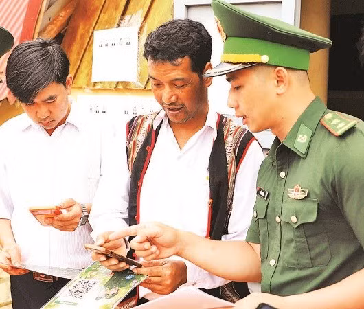 Cán bộ Đồn Biên phòng Tuy Đức hướng dẫn người dân biên giới sử dụng mã QR gửi tin báo qua “Hòm thư điện tử ẩn danh” tố giác tội phạm (Ảnh NGUYỄN NAM)