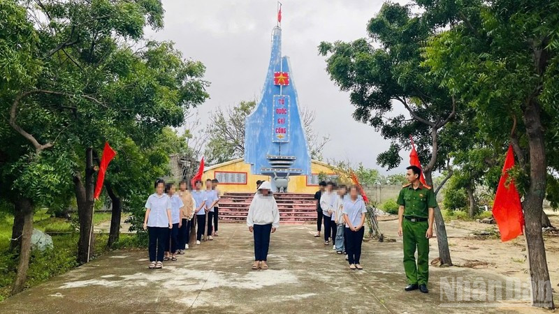 Thanh thiếu niên có hành vi vi phạm tập trung tại khuôn viên Đài tưởng niệm Liệt sĩ xã Phước Dinh để nghe Công an xã tuyên truyền, giáo dục pháp luật và tham gia lao động công ích có sự giám sát của công an xã. (Ảnh: NGUYỄN TRUNG)