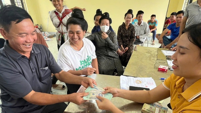 Các gia đình đồng bào dân tộc thiểu số nhận tiền chia lợi nhuận từ việc góp đất trồng cao-su.