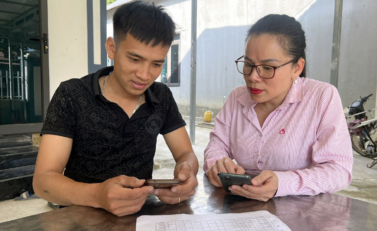 Cán bộ Phòng giao dịch Ngân hàng Chính sách xã hội huyện Mường Chà hướng dẫn Tổ trưởng tổ tiết kiệm vay vốn sử dụng ứng dụng quản lý tín dụng chính sách.