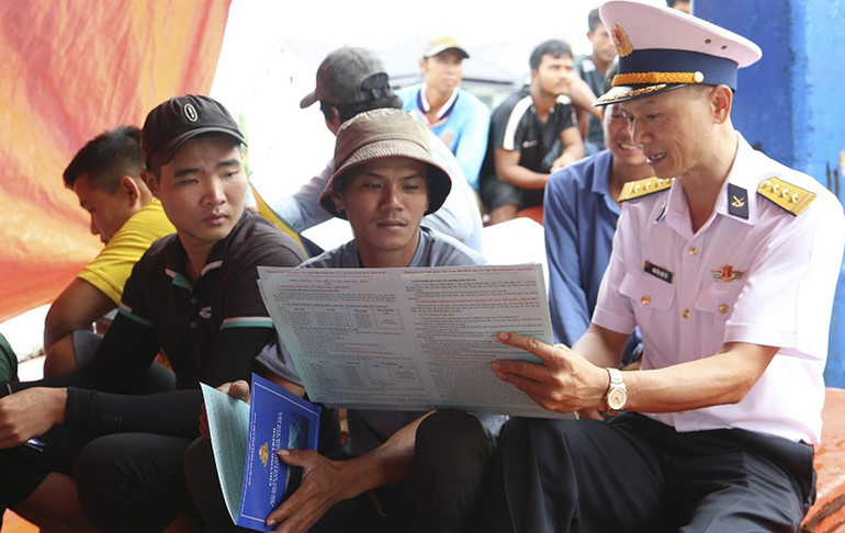 Cán bộ Vùng 2 Hải quân hướng dẫn ngư dân ở cảng cá huyện Trần Đề, tỉnh Sóc Trăng chấp hành tốt pháp luật và các quy định khi khai thác hải sản trên biển.