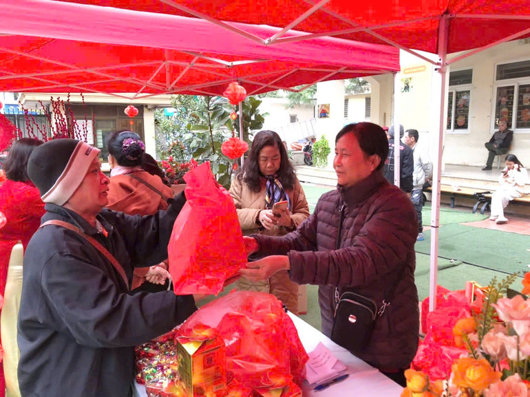 Người dân phấn khởi nhận quà tặng tại gian hàng.
