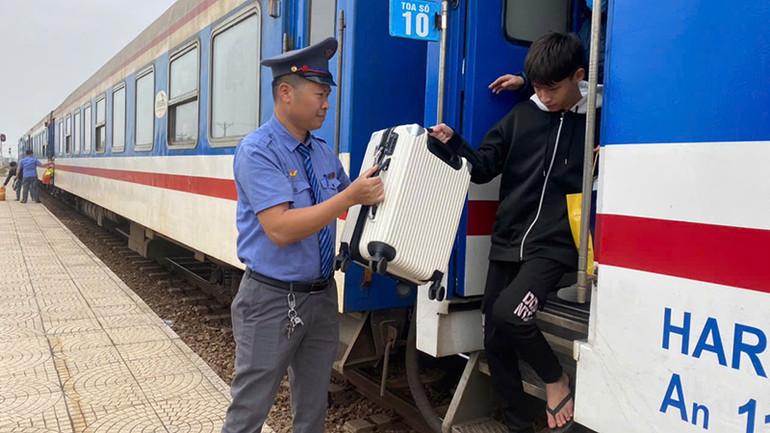 Nhân viên đường sắt hỗ trợ khách xuống tàu.