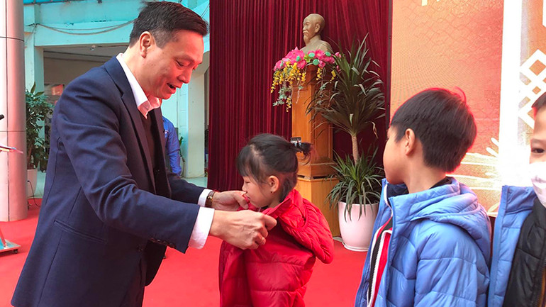 Phó Chủ tịch Ủy ban Mặt trận Tổ quốc Việt Nam quận Hai Bà Trưng Tạ Anh Tuấn tặng áo cho các cháu học sinh.