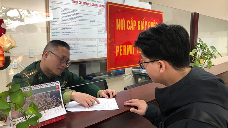 Cán bộ chiến sĩ hướng dẫn nhân viên đại lý hoàn thiện hồ sơ thủ tục.