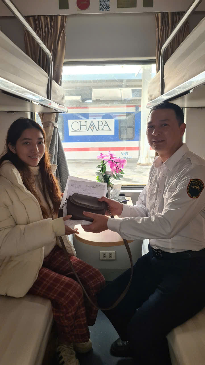 Trưởng tàu Dương Văn Toản trao trả chiếc túi xách cho hành khách Bùi Thị Hồng Nhung. Trưởng tàu Dương Văn Toản trao trả chiếc túi xách cho hành khách Bùi Thị Hồng Nhung.