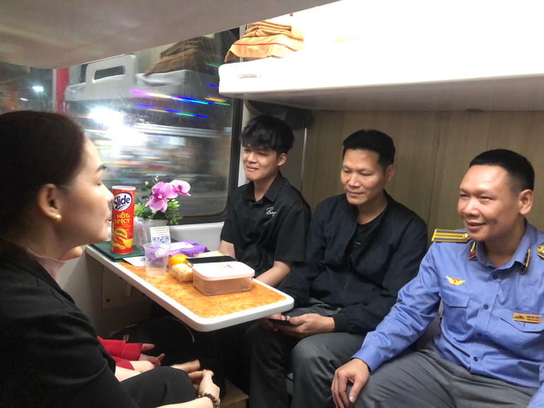 Trưởng tàu Đoàn Anh Tuấn trò chuyện với hành khách đi tàu Tết.