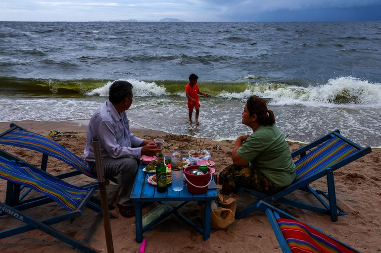 Khách du lịch ăn tối bên bãi biển có nước màu xanh lục ở Bang Saen ở tỉnh Chonburi, Thái Lan. Ảnh: Reuters.