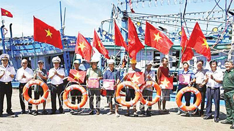 Bộ Tư lệnh Vùng 4 Hải quân trao cờ Tổ quốc, quà và phao cứu sinh cho ngư dân tại cảng cá Đá Bạc, thành phố Cam Ranh.