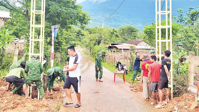 Bộ đội Biên phòng huy động thêm người dân, chủ yếu là thanh niên tham gia dựng cổng chào để làm đẹp cho bản làng.