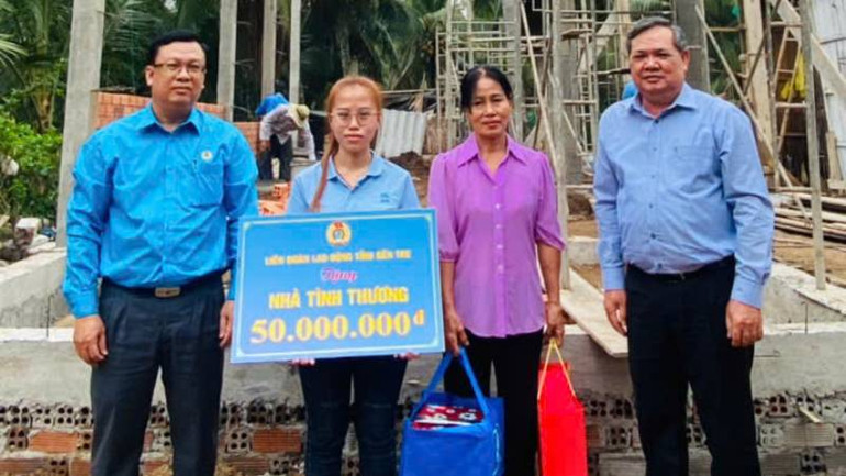 Lãnh đạo Liên đoàn Lao động tỉnh Bến Tre trao bảng hỗ trợ kinh phí xây nhà tình thương cho người lao động có hoàn cảnh khó khăn. (Ảnh: HOÀNG TRUNG)