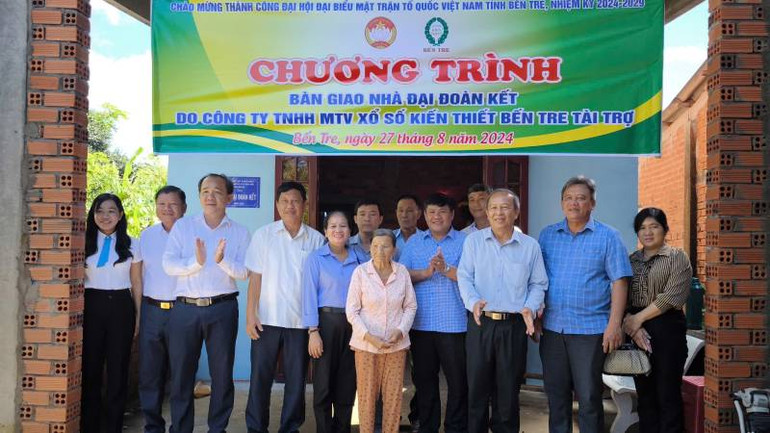 Lãnh đạo chính quyền địa phương bàn giao nhà Đại đoàn kết cho gia đình bà Trà Thị Méo. (Ảnh: HOÀNG TRUNG)