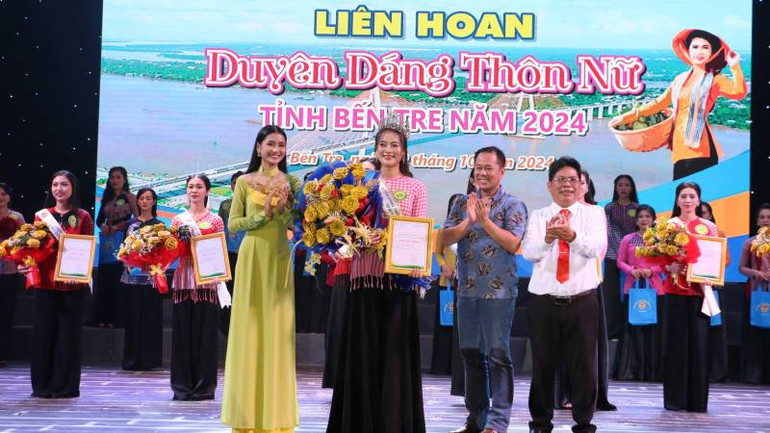 Ban tổ chức trao giải Nhất liên hoan "Duyên dáng thôn nữ" cho thí sinh Nguyễn Thị Ngọc Trinh. (Ảnh: HOÀNG TRUNG)