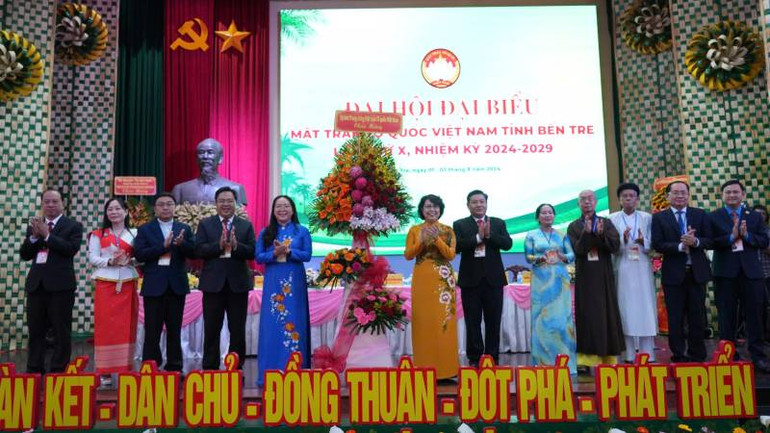 Phó Chủ tịch Ủy ban Trung ương Mặt trận Tổ quốc Việt Nam Tô Thị Bích Châu tặng hoa chúc mừng Đại hội. (Ảnh: HOÀNG TRUNG)