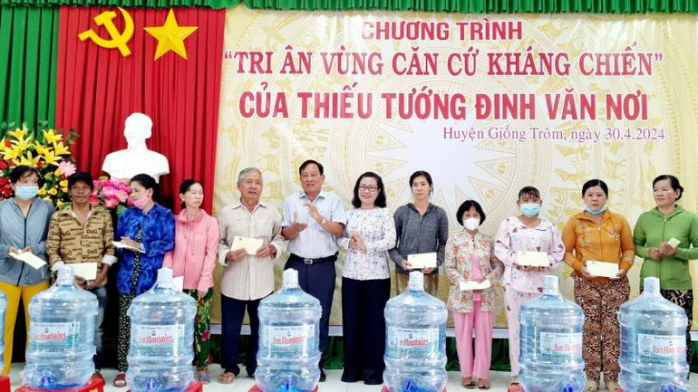 Lãnh đạo chính quyền địa phương trao quà, nước khoáng cho gia đình chính sách.