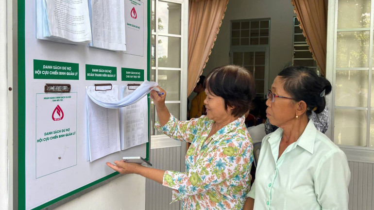 Người dân tìm hiểu thông tin về vay vốn, thủ tục, dư nợ tại điểm giao dịch của Ngân hàng Chính sách xã hội. (Ảnh: HOÀNG TRUNG)