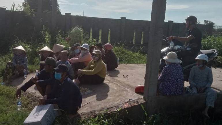 Người dân tập trung ngăn không cho xe vào bãi rác An Hiệp. (Ảnh: HOÀNG TRUNG)