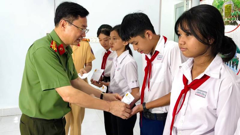 Đại tá Trương Sơn Lâm, Giám đốc Công an tỉnh Bến Tre trao học bổng cho học sinh nghèo, hiếu học. (Ảnh: HOÀNG TRUNG)