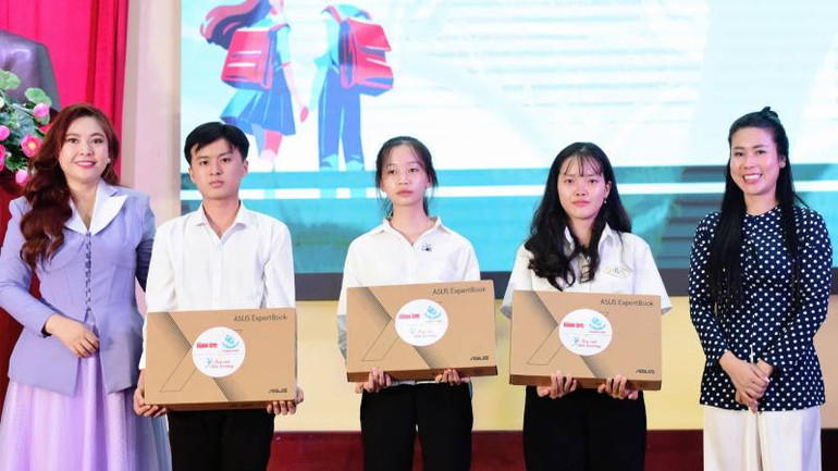Đại diện Quỹ khuyến học Vinacam trao máy tính xách tay cho sinh viên khó khăn, thiếu thiết bị học tập. (Ảnh: HOÀNG TRUNG)