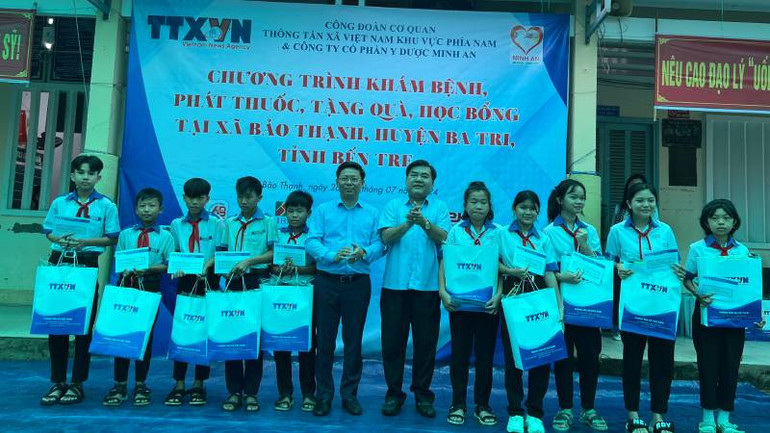 Lãnh đạo chính quyền địa phương cùng Ban tổ chức trao học bổng cho học sinh nghèo, vượt khó học giỏi. (Ảnh: HOÀNG TRUNG)