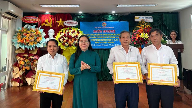 Chủ tịch Ủy ban Mặt trận Tổ quốc Việt Nam tỉnh Bến Tre Nguyễn Thị Hồng Nhung trao Bằng khen cho tập thể đạt thành tích xuất sắc. (Ảnh: HOÀNG TRUNG)