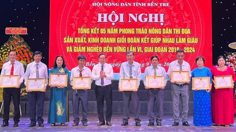 Chủ tịch Ủy ban nhân dân tỉnh Bến Tre Trần Ngọc Tam trao Bằng khen cho các cá nhân có thành tích xuất sắc trong phong trào nông dân sản xuất, kinh doanh giỏi. (Ảnh: HOÀNG TRUNG)