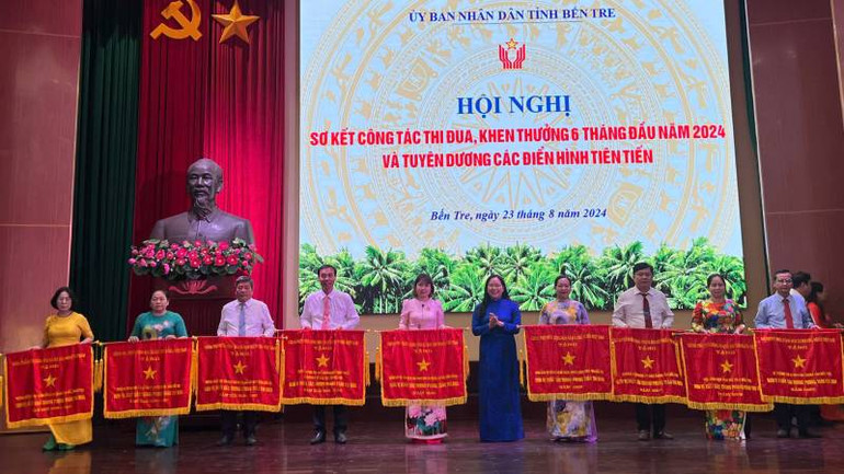 Lãnh đạo tỉnh Bến Tre trao cờ thi đua cho các đơn vị có thành tích xuất sắc. (Ảnh: HOÀNG TRUNG)