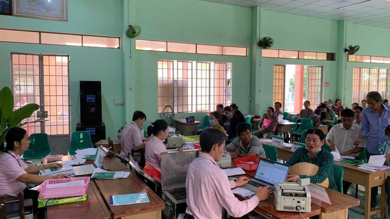 Giải ngân vốn tại điểm giao dịch xã Nhuận Phú Tân của Ngân hàng Chính sách xã hội huyện Mỏ Cày Bắc. (Ảnh: HOÀNG TRUNG)