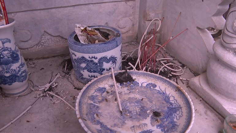 Bát hương trên các phần mộ bị hai đối tượng rút hết chân nhang để tìm tiền.