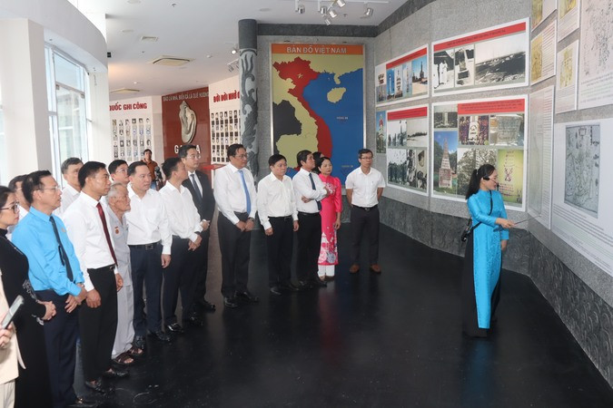 Đại biểu nghe thuyết minh viên giới thiệu Khu bảo tàng trưng bày kỷ vật của liệt sĩ. (Ảnh: XUÂN THÀNH)