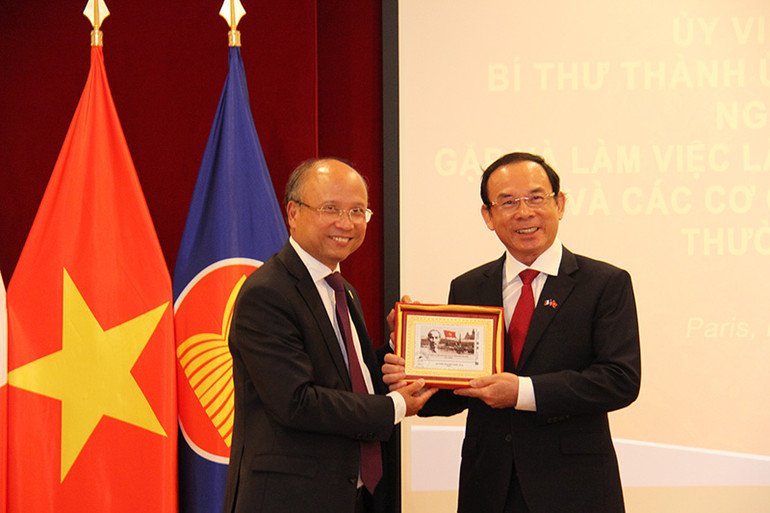 Đại sứ Đinh Toàn Thắng trao tặng Bí thư Thành ủy Nguyễn Văn Nên bức tranh tem Bác Hồ do Bưu điện Pháp phát hành nhân dịp kỷ niệm 100 năm Ngày Bác Hồ đặt chân đến Pháp. (Ảnh: Khải Hoàn)