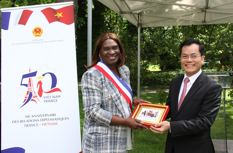 Thứ trưởng Ngoại giao Hà Kim Ngọc tặng tranh tem kỷ niệm 100 năm Bác Hồ đặt chân đến Pháp do Bưu điện Pháp phát hành cho Phó Thị trưởng Djénéba Keita. (ẢNH: KHẢI HOÀN)