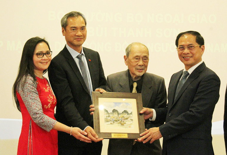 Bộ trưởng Bùi Thanh Sơn tặng quà lưu niệm cho đại diện Hội Người Việt Nam tại Pháp. (Ảnh: Khải Hoàn)