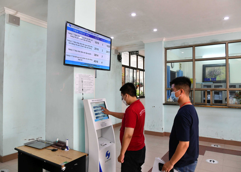 Người dân đăng ký dịch vụ trên máy lấy số xếp hàng tự động tại Cục Sở hữu trí tuệ. (Ảnh HÀ MY)