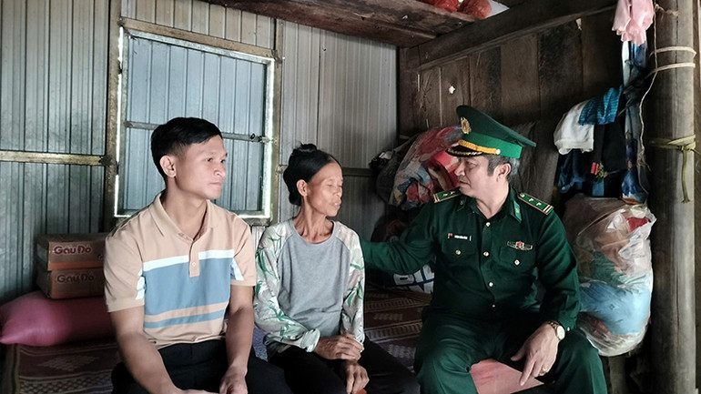 Trung tá Hoàng Công Hùng, Đồn trưởng Biên phòng Cà Xèng, thăm hỏi, tặng quà hộ dân.