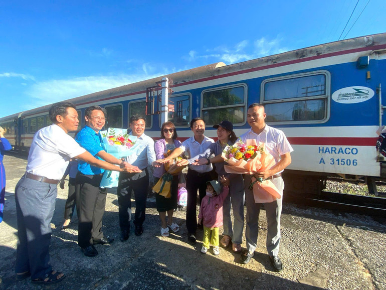 Tặng hoa những hành khách đầu tiên tàu SE6 xuống ga Mỹ Trạch.