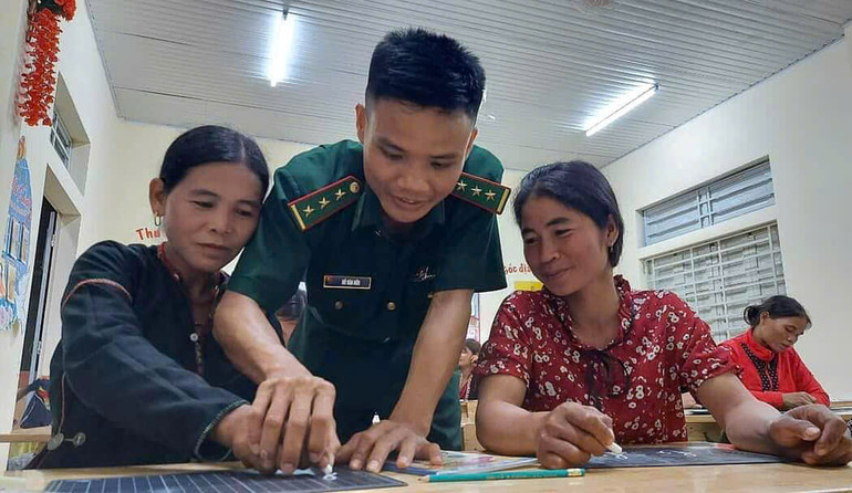 Thầy giáo Hồ Văn Hữu hướng dẫn học viên tập viết chữ cái.