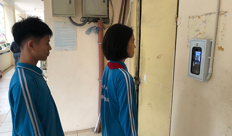 Học sinh điểm danh nhận diện khuôn mặt trước khi vào lớp.