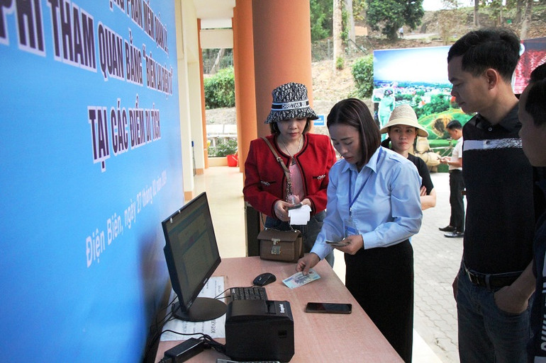 Nhân viên điểm di tích đồi A1 hướng dẫn khách tham quan sử dụng phần mềm thu phí điện tử.