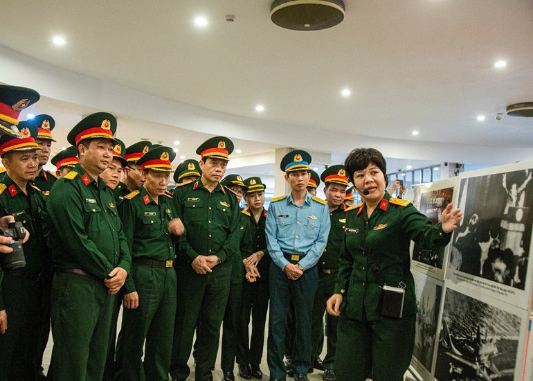 Hướng dẫn viên thuyết trình tại triển lãm ảnh về diễn biến, kết quả, ý nghĩa của các chiến thắng Điện Biên Phủ và Hà Nội-Điện Biên Phủ trên không.