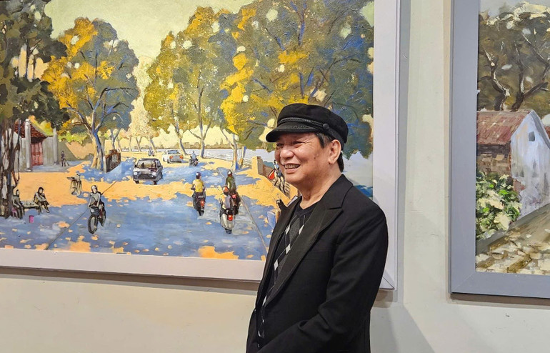 Họa sĩ Nguyễn Quốc Thắng bên tác phẩm tại triển lãm.