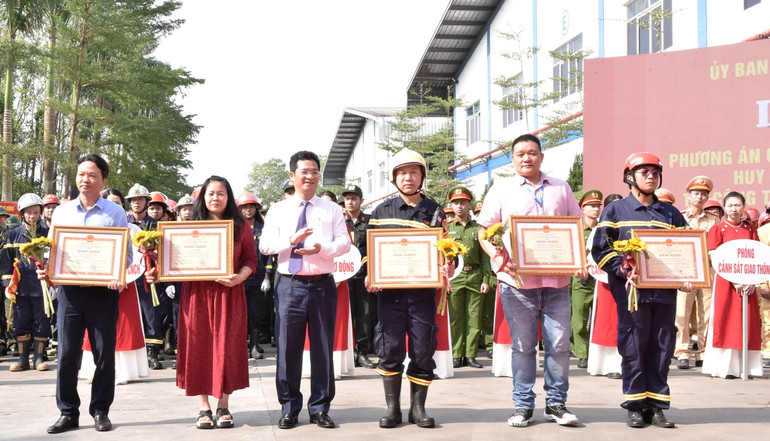 Đồng chí Phó Chủ tịch Thường trực Ủy ban nhân dân tỉnh Nam Định Trần Anh Dũng trao bằng khen cho các tập thể và cá nhân có thành tích xuất sắc trong diễn tập. (Ảnh: XUÂN TRƯỜNG)