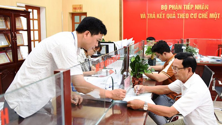 Cán bộ xã Giao Phong, huyện Giao Thủy (Nam Định) hướng dẫn người dân đến làm thủ tục hành chính tại Bộ phận tiếp nhận và trả kết quả theo cơ chế một cửa.