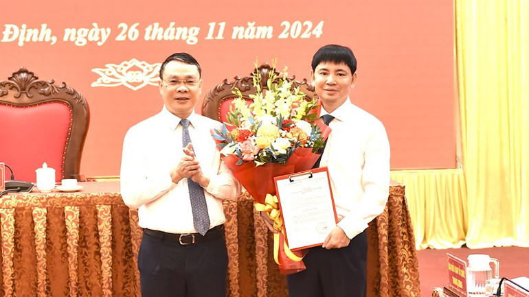 Đồng chí Bí thư Tỉnh ủy Nam Định Đặng Khánh Toàn trao quyết định và chúc mừng đồng chí Nguyễn Hoàng Anh được Ban Bí thư Trung ương Đảng chỉ định tham gia Ban Chấp hành Đảng bộ tỉnh Nam Định nhiệm kỳ 2020-2025. (Ảnh: XUÂN TRƯỜNG)