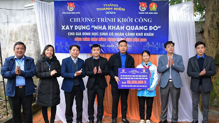 Các đại biểu trao tiền hỗ trợ xây dựng Nhà khăn quàng đỏ cho học sinh có hoàn cảnh khó khăn. Ảnh: NGỌC HÀ